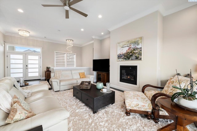 living room with french doors, ornamental molding, a glass covered fireplace, and recessed lighting