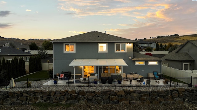 back house at dusk with a patio