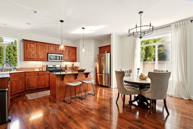 6117 Dorchester Ct, Pasco, WA 99301 - kitchen with appliances with stainless steel finishes, dark wood finished floors, a center island, a breakfast bar, and recessed lighting
