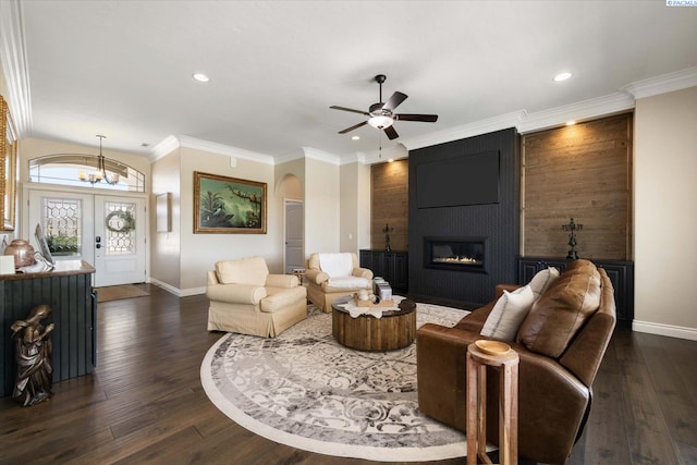 living area with baseboards, arched walkways, dark wood-type flooring, a fireplace, and recessed lighting
