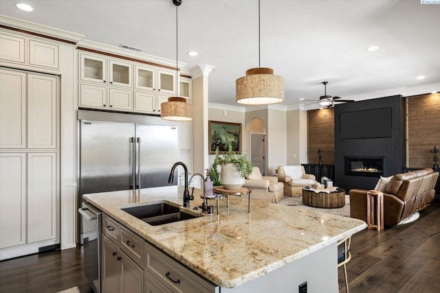 kitchen featuring a sink, crown molding, ceiling fan, a fireplace, and recessed lighting