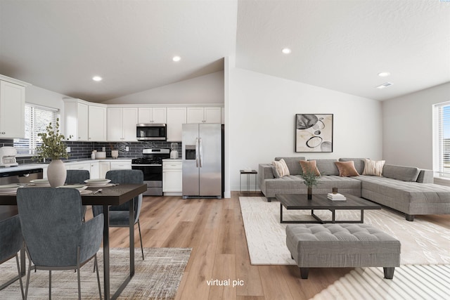 living room featuring light hardwood / wood-style flooring and vaulted ceiling