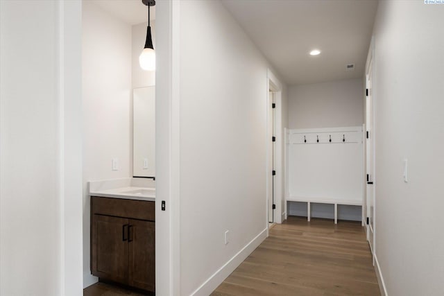 hallway featuring recessed lighting, light wood-style floors, and baseboards