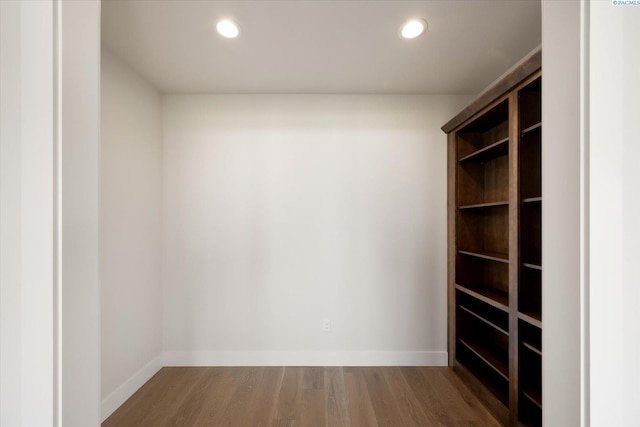 walk in closet with wood finished floors