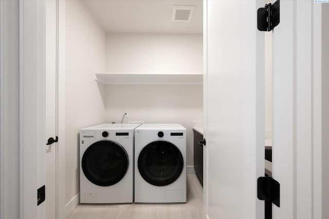 laundry room with independent washer and dryer, visible vents, laundry area, and baseboards