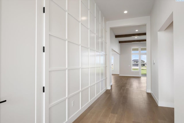 hall featuring wood-type flooring, baseboards, recessed lighting, and beamed ceiling