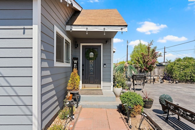 property entrance with fence and a patio area