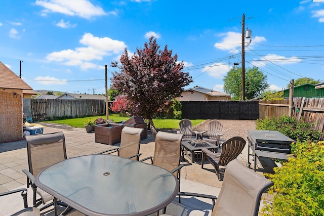 view of patio / terrace featuring outdoor dining area, a fenced backyard, and an outdoor fire pit