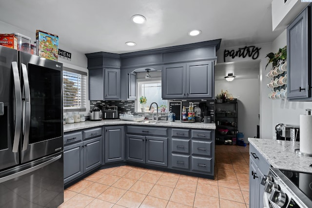 kitchen with decorative backsplash, a sink, gray cabinetry, stainless steel appliances, and recessed lighting