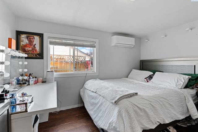 bedroom with baseboards, a wall mounted AC, and wood finished floors