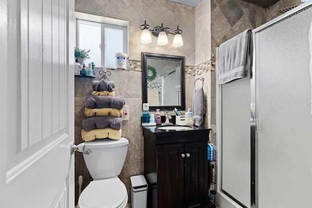 full bath with vanity, toilet, tile walls, and a stall shower