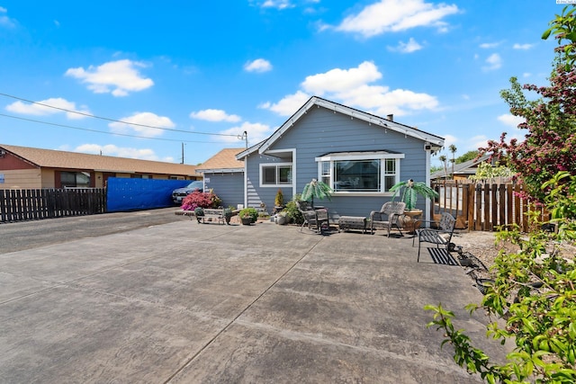 rear view of house with fence and a patio area
