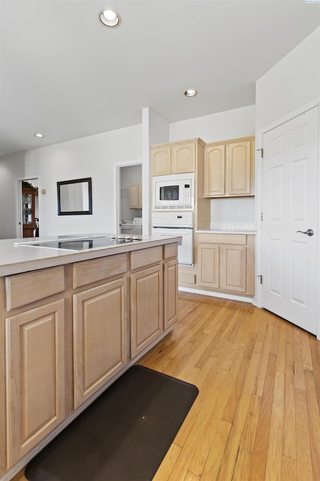 kitchen with white appliances, light brown cabinetry, and light hardwood / wood-style flooring