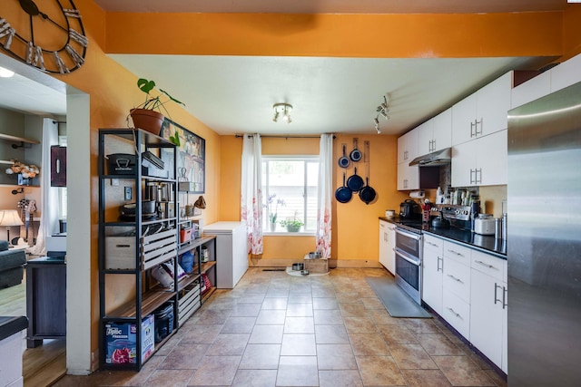 1804 Cedar St, Colfax, WA 99111 - kitchen with stainless steel appliances, under cabinet range hood, white cabinetry, and dark countertops