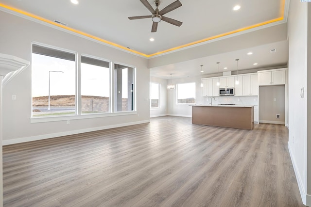 unfurnished living room with ceiling fan and light hardwood / wood-style floors