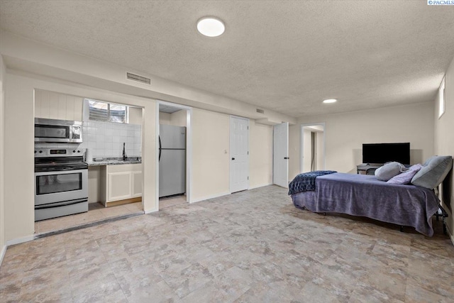 1807 Stevens Dr, Richland, WA 99354 - bedroom featuring freestanding refrigerator, a textured ceiling, a sink, recessed lighting, and baseboards