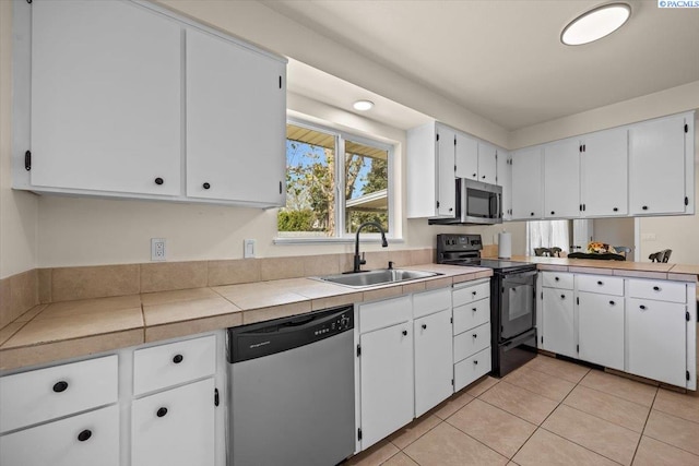 1807 Stevens Dr, Richland, WA 99354 - kitchen featuring appliances with stainless steel finishes, a sink, white cabinets, and light tile patterned floors