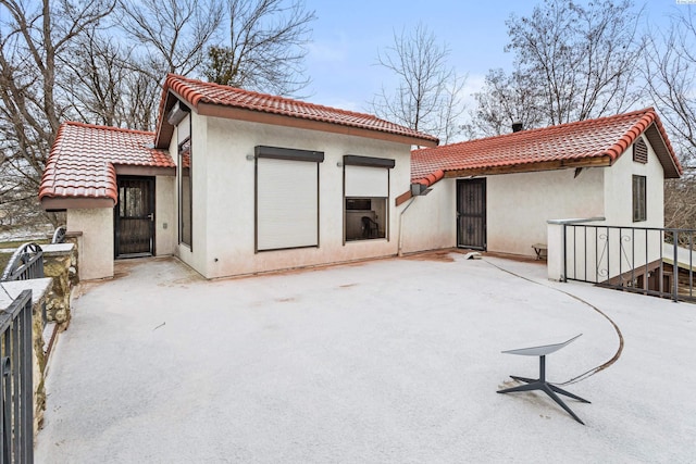 back of property featuring stucco siding, a patio area, and a tile roof