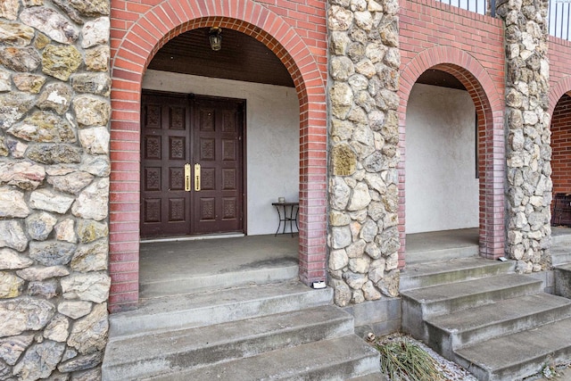 property entrance with brick siding and stone siding