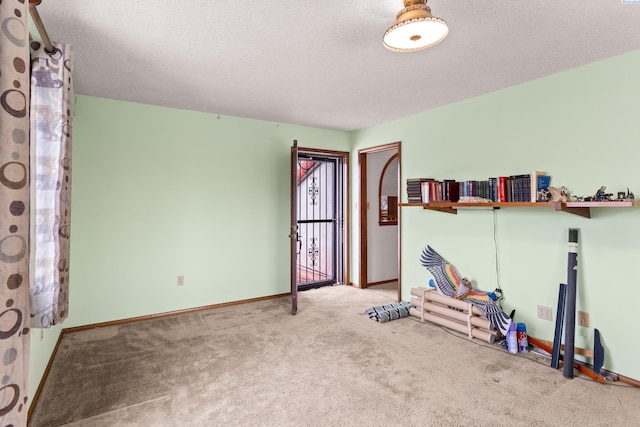 interior space featuring a textured ceiling, baseboards, and carpet floors