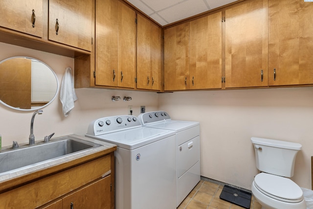 laundry area with light tile patterned floors, laundry area, washing machine and dryer, and a sink