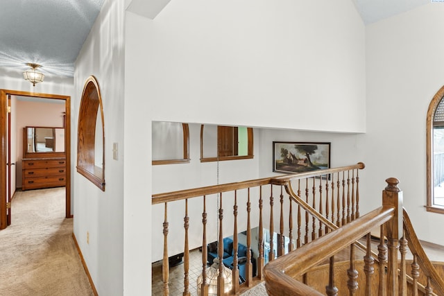 stairway with baseboards and carpet