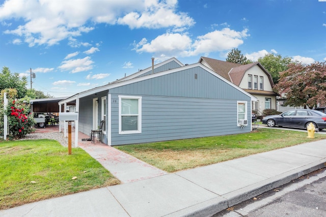 view of side of home featuring a lawn and a carport