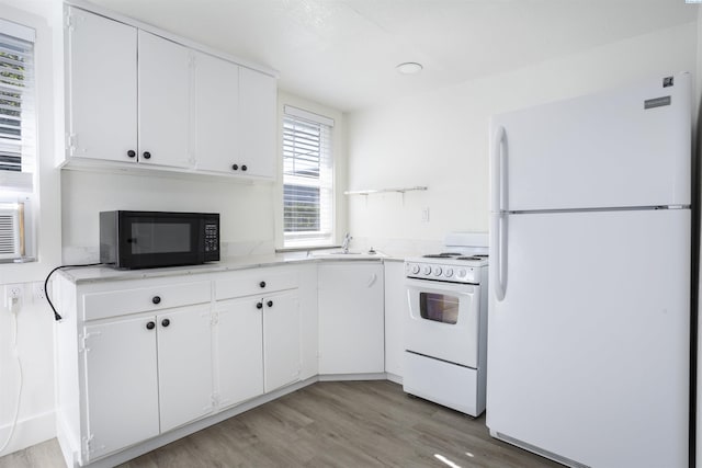 kitchen featuring white cabinetry, white appliances, sink, and light hardwood / wood-style floors