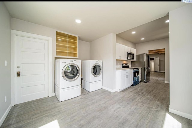 washroom with washer and clothes dryer and light hardwood / wood-style flooring