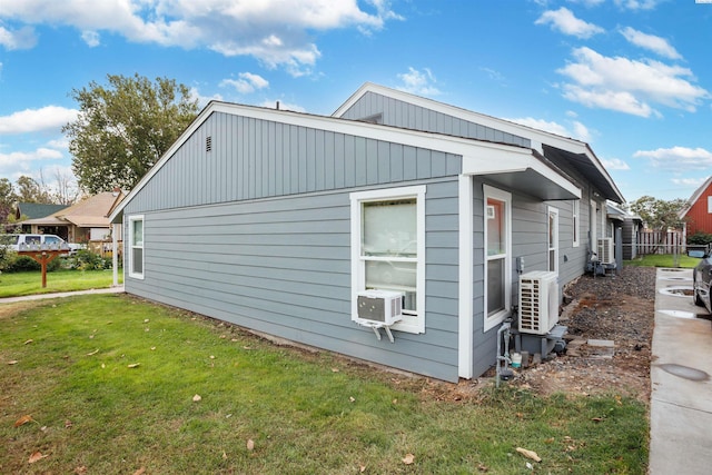 view of home's exterior with cooling unit, a yard, and ac unit