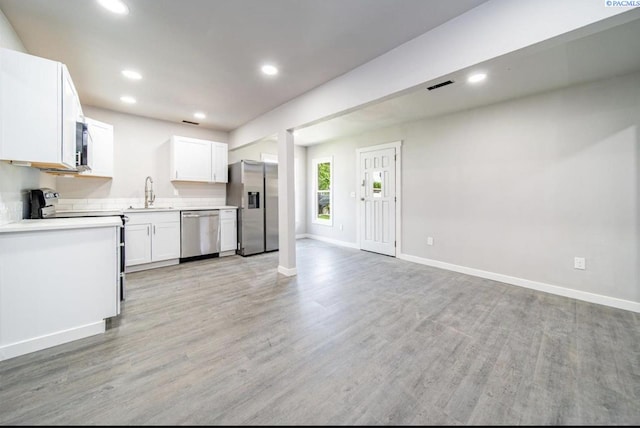 kitchen featuring sink, light hardwood / wood-style flooring, stainless steel appliances, and white cabinets