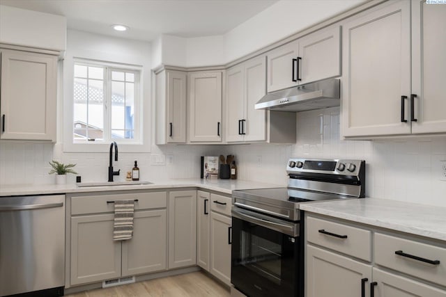 326 Casi Ct, Prosser, WA 99350 - kitchen with under cabinet range hood, a sink, gray cabinetry, tasteful backsplash, and appliances with stainless steel finishes