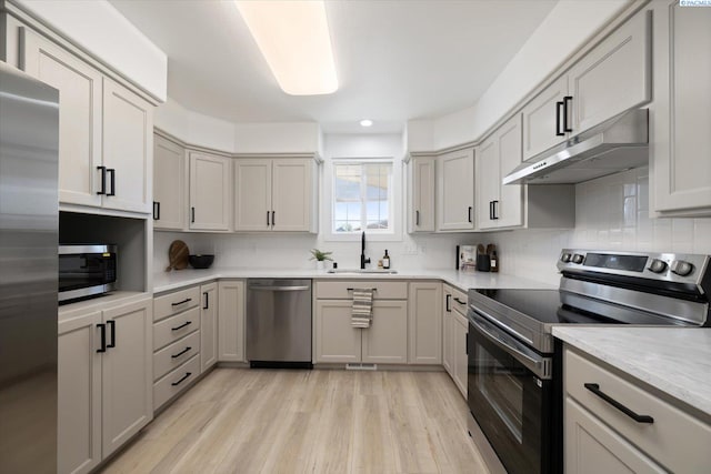326 Casi Ct, Prosser, WA 99350 - kitchen featuring stainless steel appliances, a sink, tasteful backsplash, light wood-type flooring, and under cabinet range hood