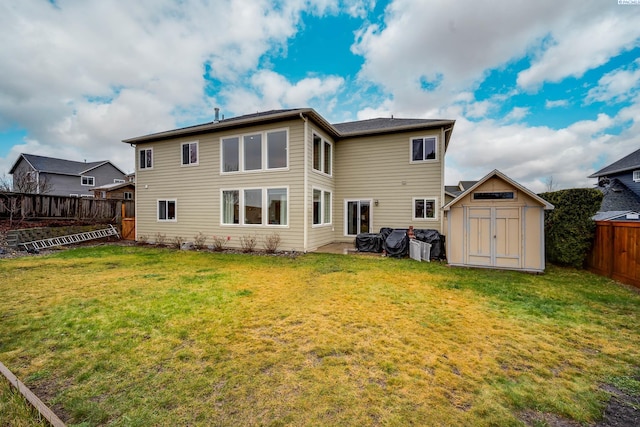 rear view of property with a yard and a shed