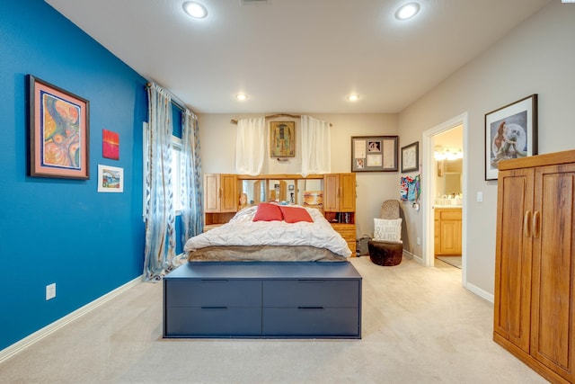 bedroom with light colored carpet and connected bathroom