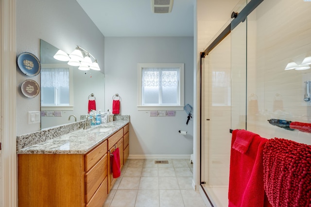 bathroom featuring a shower with door, vanity, and tile patterned floors