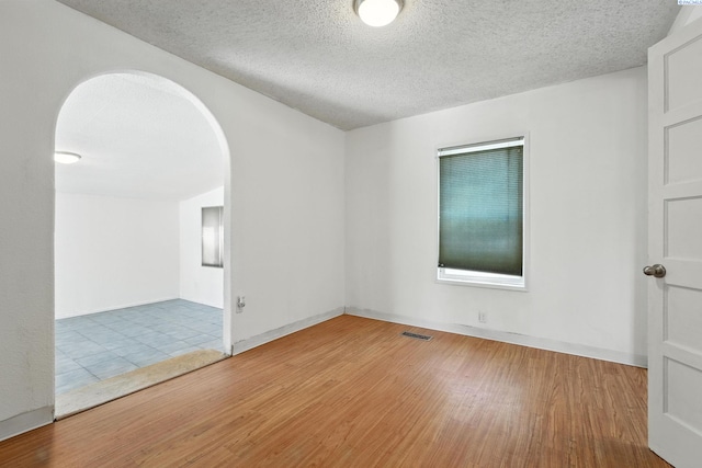323 S Beech St, Kennewick, WA 99336 - unfurnished room with arched walkways, wood finished floors, and a textured ceiling