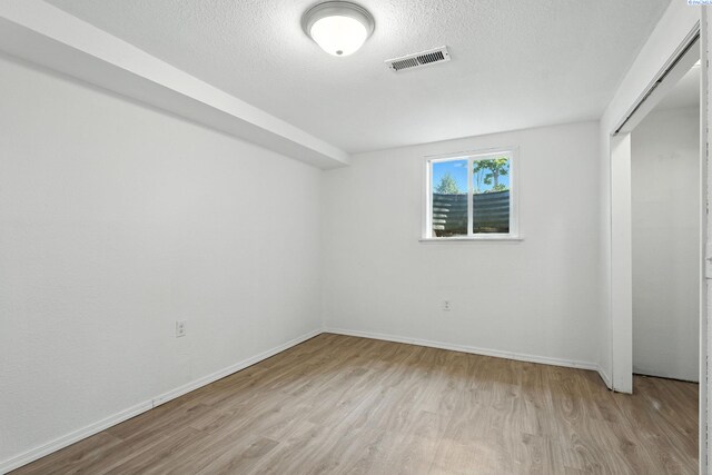 323 S Beech St, Kennewick, WA 99336 - unfurnished bedroom featuring light wood-style flooring, a textured ceiling, and a closet