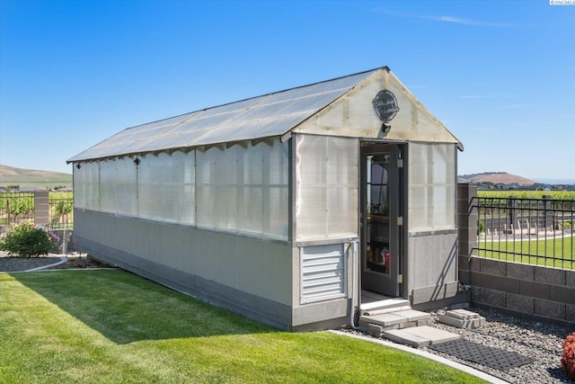 view of outbuilding featuring a mountain view and a lawn