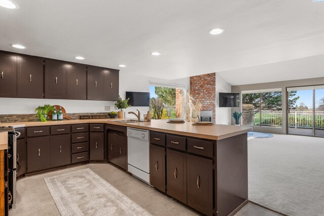 kitchen with a peninsula, dishwasher, a wealth of natural light, and a sink