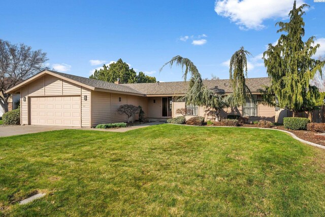 ranch-style house featuring a front lawn, driveway, and a garage