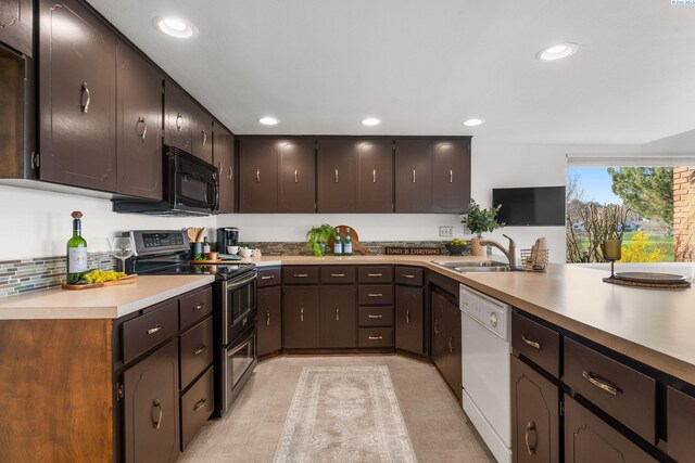 kitchen featuring white dishwasher, a sink, black microwave, double oven range, and recessed lighting