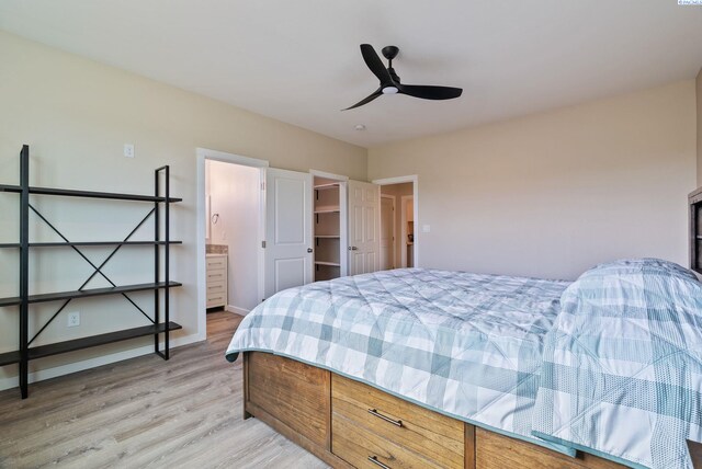 bedroom featuring a ceiling fan, light wood finished floors, and a spacious closet