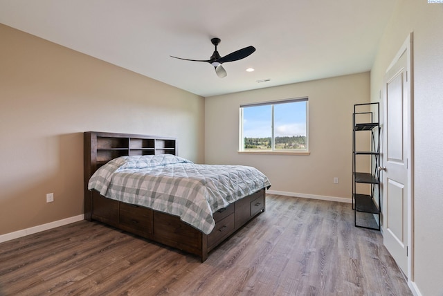 bedroom with baseboards, wood finished floors, and visible vents