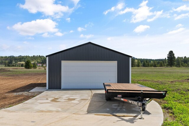 detached garage featuring a view of trees