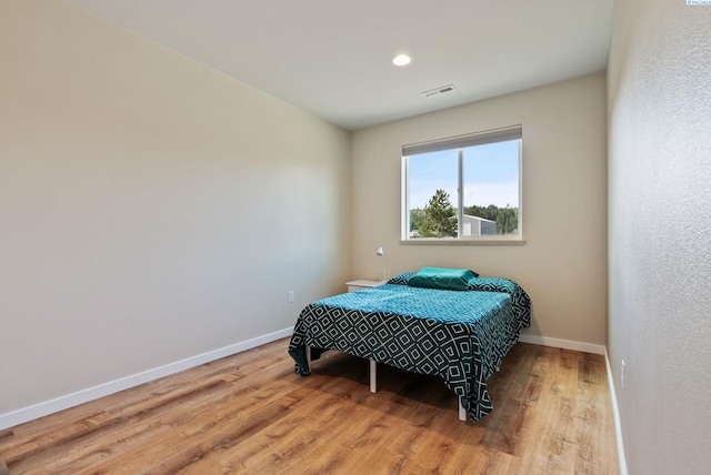 bedroom featuring baseboards, recessed lighting, wood finished floors, and visible vents