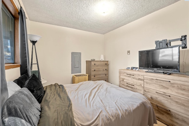 bedroom featuring electric panel and a textured ceiling