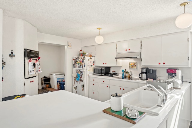 kitchen featuring pendant lighting, sink, white appliances, a textured ceiling, and white cabinets