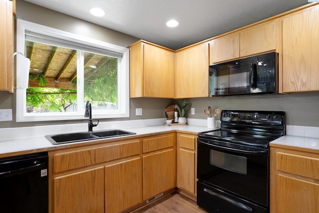 5501 Maui Ct, West Richland, WA 99353 - kitchen featuring black appliances, a sink, light countertops, wood finished floors, and recessed lighting