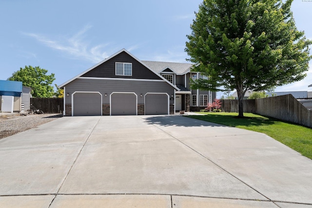 5501 Maui Ct, West Richland, WA 99353 - view of front of home with driveway, stone siding, and a garage